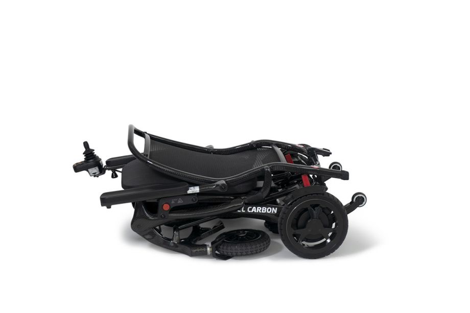 Auf dem Bild ist der Ausschnitt eines PKW-Kofferraumes zu sehen. Eine Frauenhand hebt die Antriebseinheit problemlos und mit einer Hand in den Kofferraum.