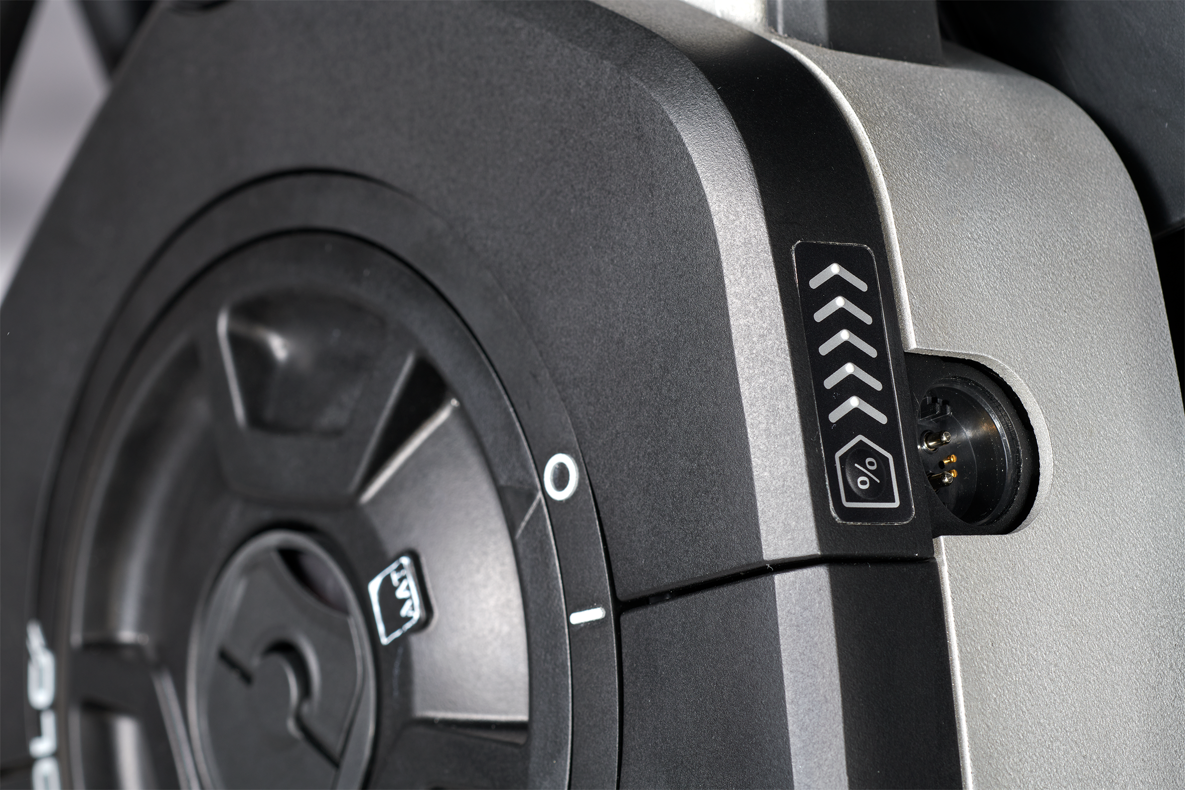 Das Bild zeigt eine Detailaufnahme des Antriebsrades des Rollstuhlantriebs SOLO² der Firma AAT aus Albstadt. Zu sehen ist die Ladebuchse, über welche direkt innerhalb des Rades die integrierten Akkus aufgeladen werden können. Die Buchse ist zudem spritzwassergeschützt.