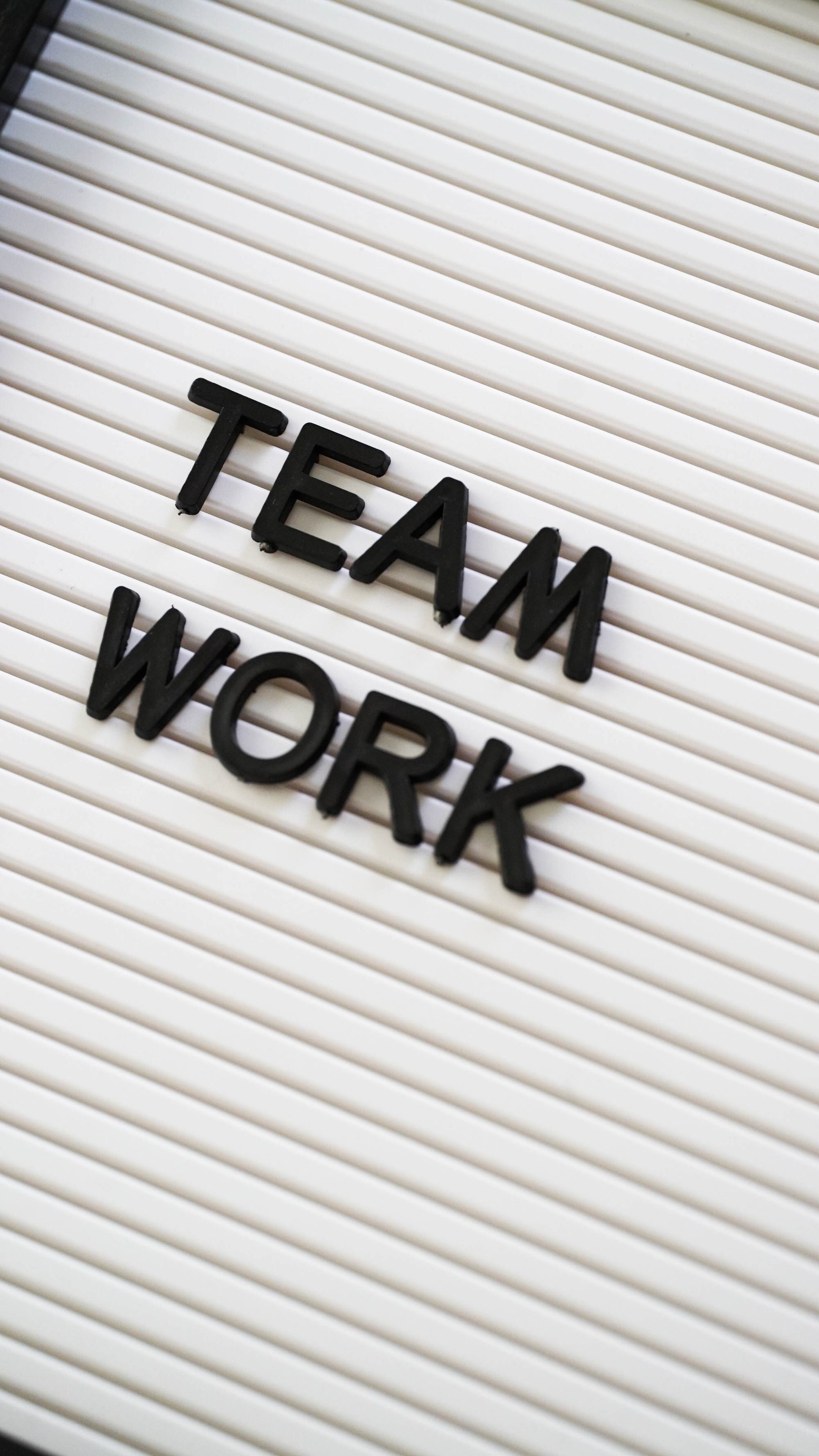Das Bild zeigt einen weißen Hintergrund, auf dem der Schriftzug „Teamwork“ in 3D aufgesteckt ist. Dieses Bild symbolisierte die Zusammenarbeit mit dem AAT-Marketingteam hinsichtlich gemeinsamer Werbung. 
