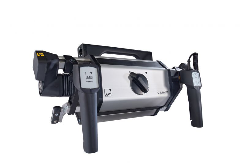 Das Bild zeigt die freigestellte Antriebseinheit der Schiebe- und Bremshilfe von AAT V-MAX2 auf weißem Hintergrund. Zu sehen ist der komplette Rollstuhlantrieb von vorne. Es wird das silberne Gehäuse selbst, der Entriegelungsschalter sowie der Bedien- und Schiebegriff, über welchen der Rollstuhl bewegt werden kann, gezeigt.