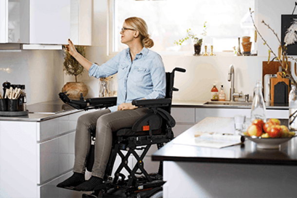 Das Bild zeigt einen Rollstuhl mit Hebesystem, welches von der Firma REAC produziert wird