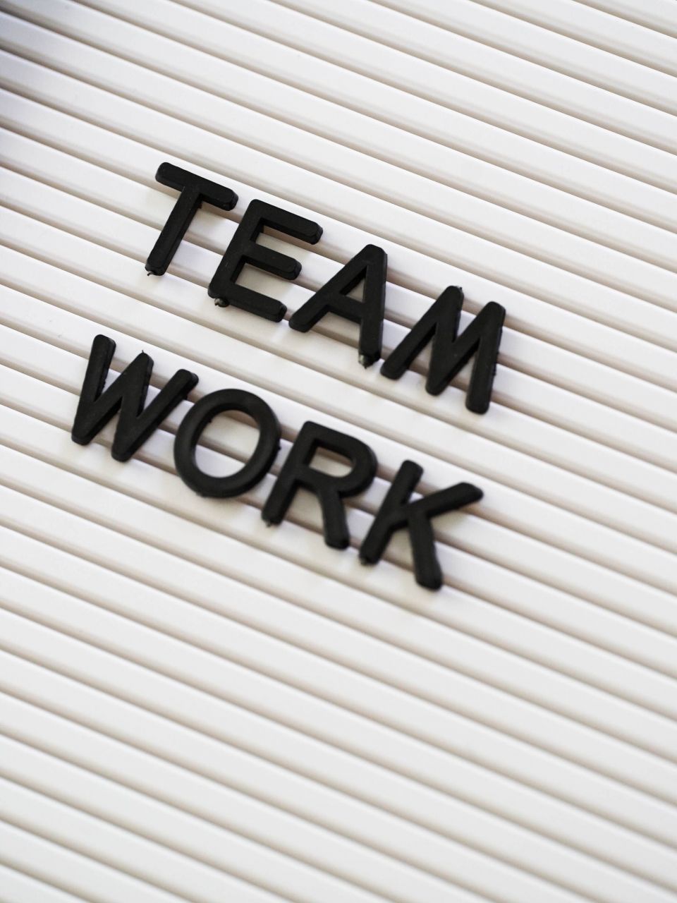Das Bild zeigt einen weißen Hintergrund, auf dem der Schriftzug „Teamwork“ in 3D aufgesteckt ist. Dieses Bild symbolisierte die Zusammenarbeit mit dem AAT-Marketingteam hinsichtlich gemeinsamer Werbung. 